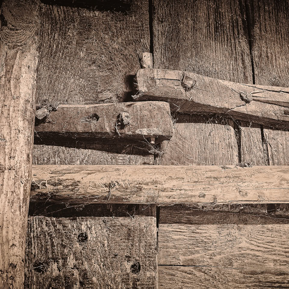 Old wooden hinges on a rustic wooden door.