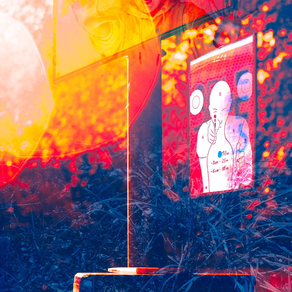 A vibrant, abstract image with overlapping colors of red, orange, and blue, featuring a partially visible sign and a poster with a person on it.
