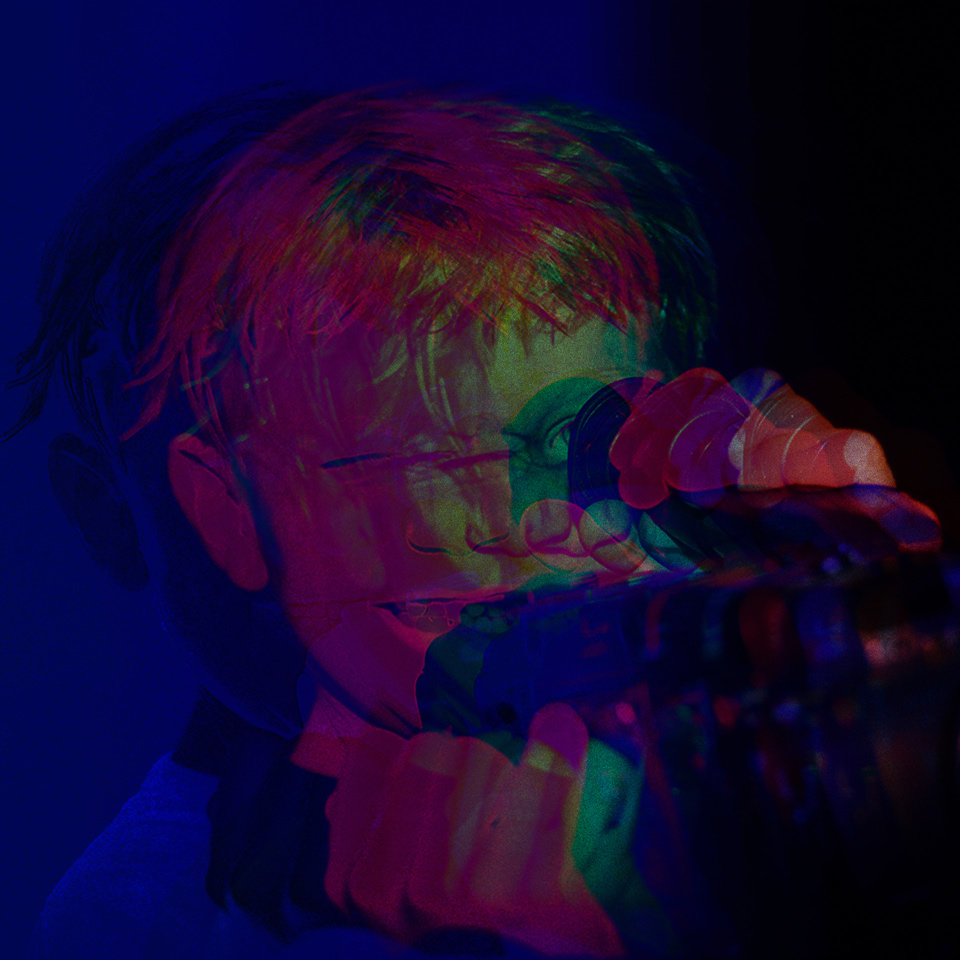 A person with glasses holding a camera, with a colorful, distorted overlay effect.